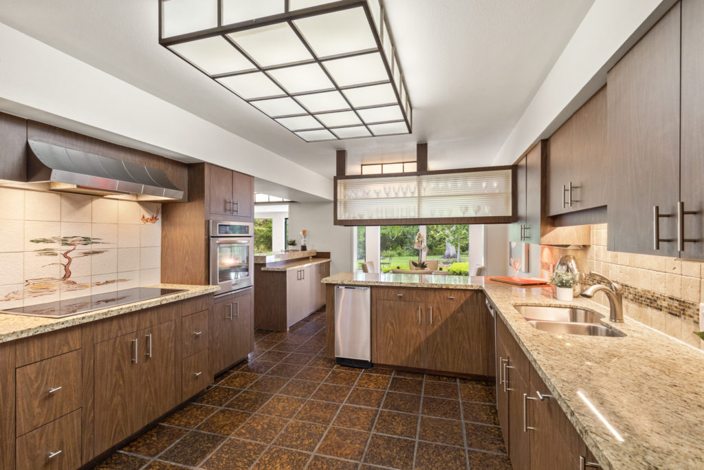 The kitchen at 503 Timber Terrace Road has the original cabinetry and lighting with upgraded granite counter tops. (Photo by Nan Studios)