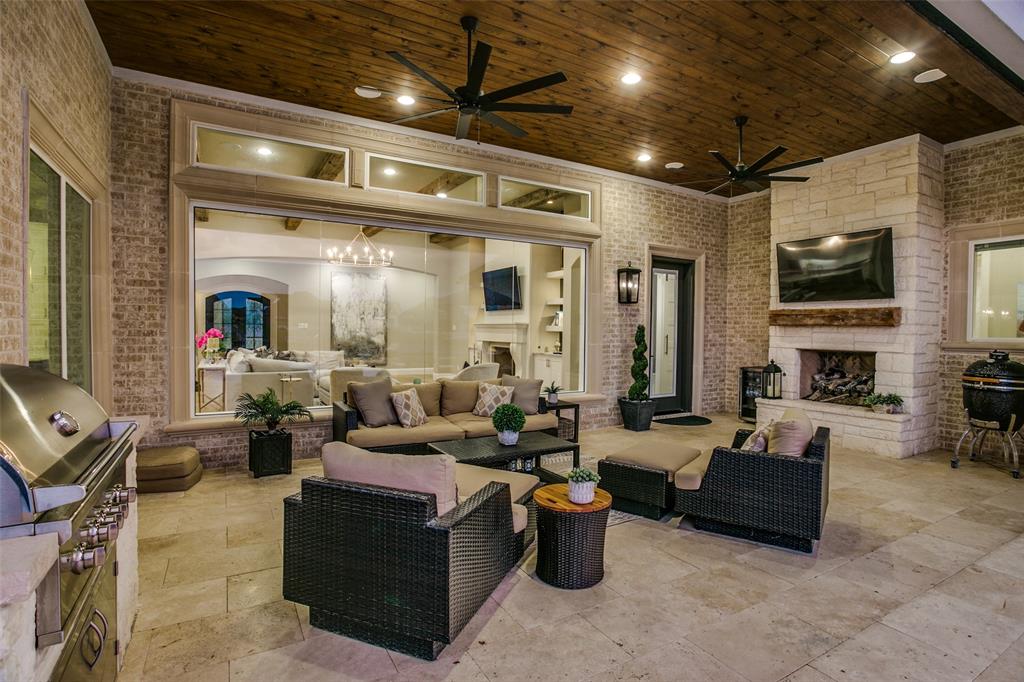 The outdoor living space with full kitchen, and fireplace, afford a view of the the pool and lake.