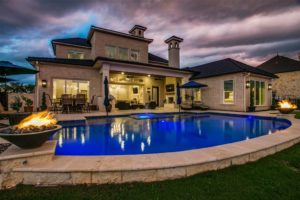 6025 Lakeside – with a dramatic pool, fire urns and its own water feature.