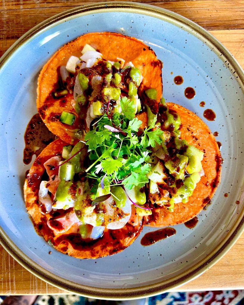 La Onda – Happy is never boring at La Onda. Pictured here a seafood campechana with scallops, bay scallops, and coho salmon in aji basil aguachile served on tostadas.