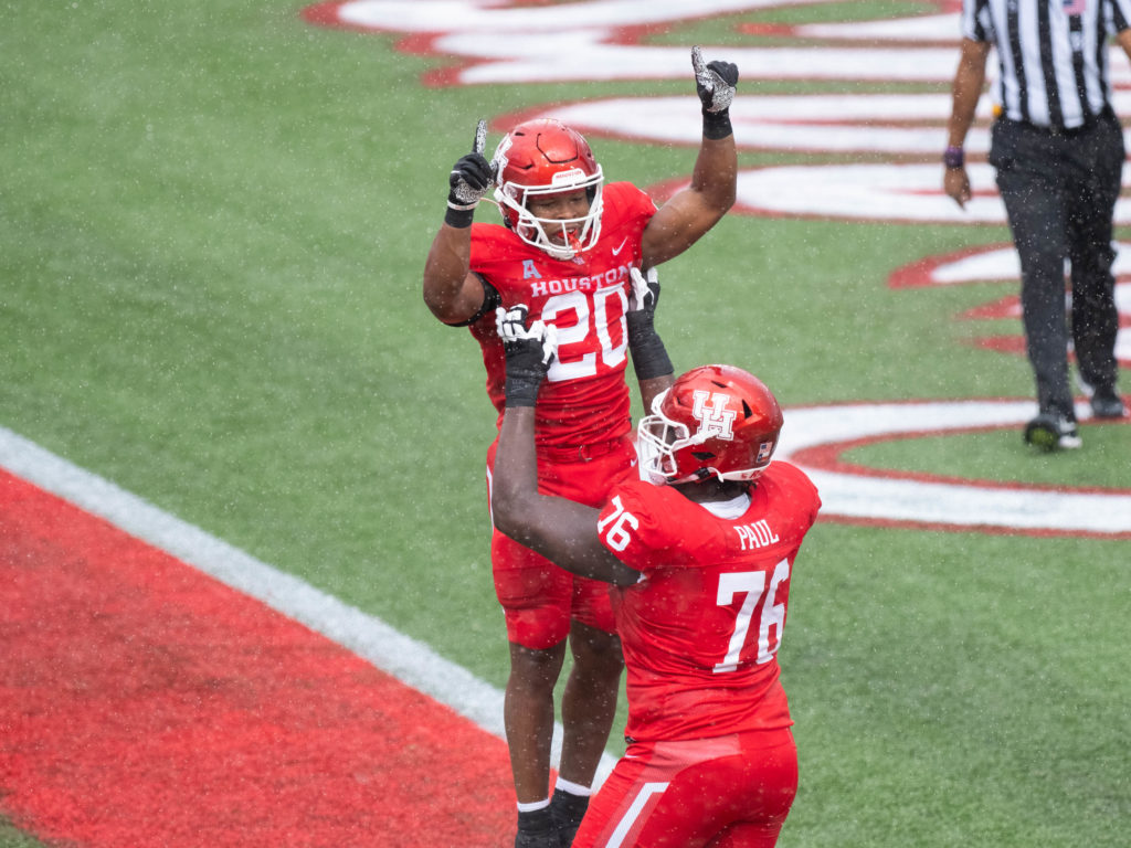 After he scored on a 40 yard run, Brandon Campbell got a big lift from UH left tackle Patrick Paul. (Photo by F. Carter Smith)