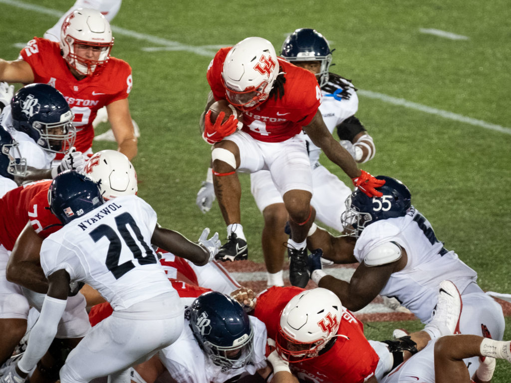 UH running back Ta'Zhawn Henry went high to try and clear the pile.  (Photo by F. Carter Smith)