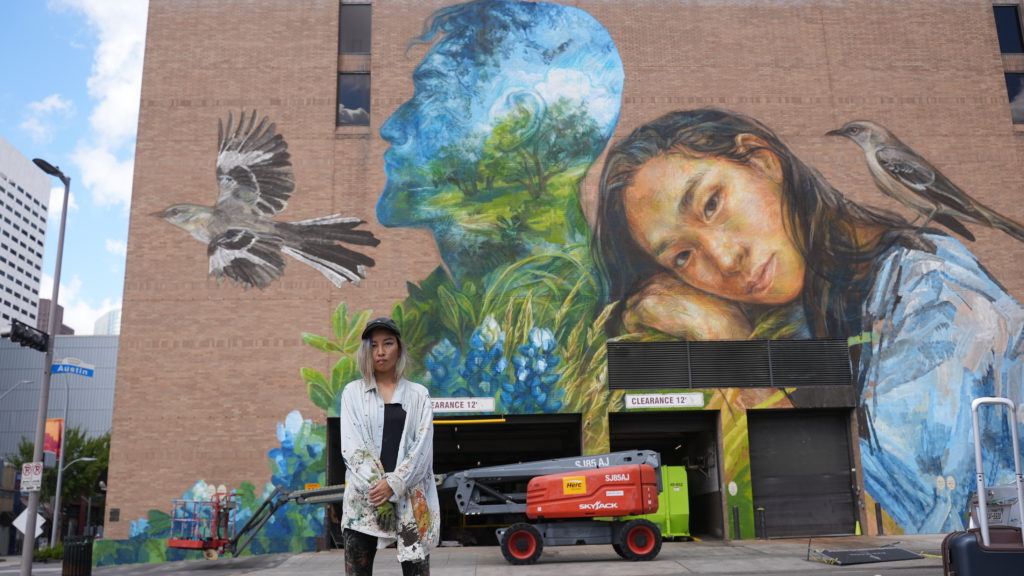 Emily Ding stands in front of her completed mural, "Loving Houston." (Photo by @superkant and @cyvisuals_, courtesy Street Art for Mankind)