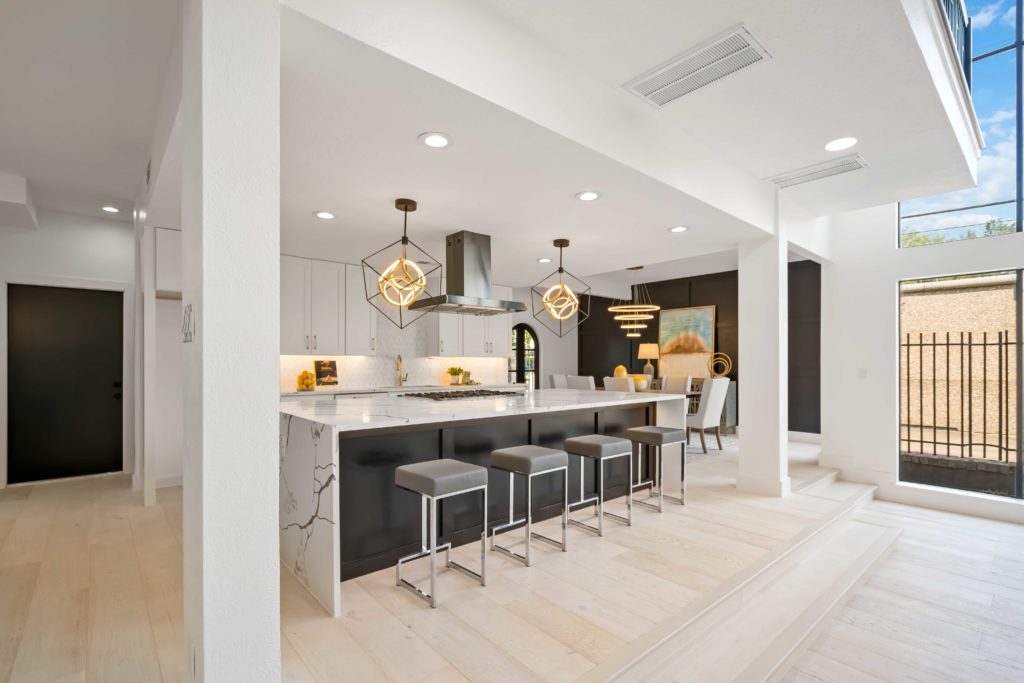 The kitchen is one of the home's most stunning spaces, between its luxurious appliances, cascading waterfall island and eye-catching light fixtures.
