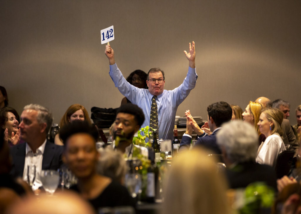 An enthusiastic bidder wields his paddle at the FotoFest Fine Print Auction. (Photo by Tere Garcia)