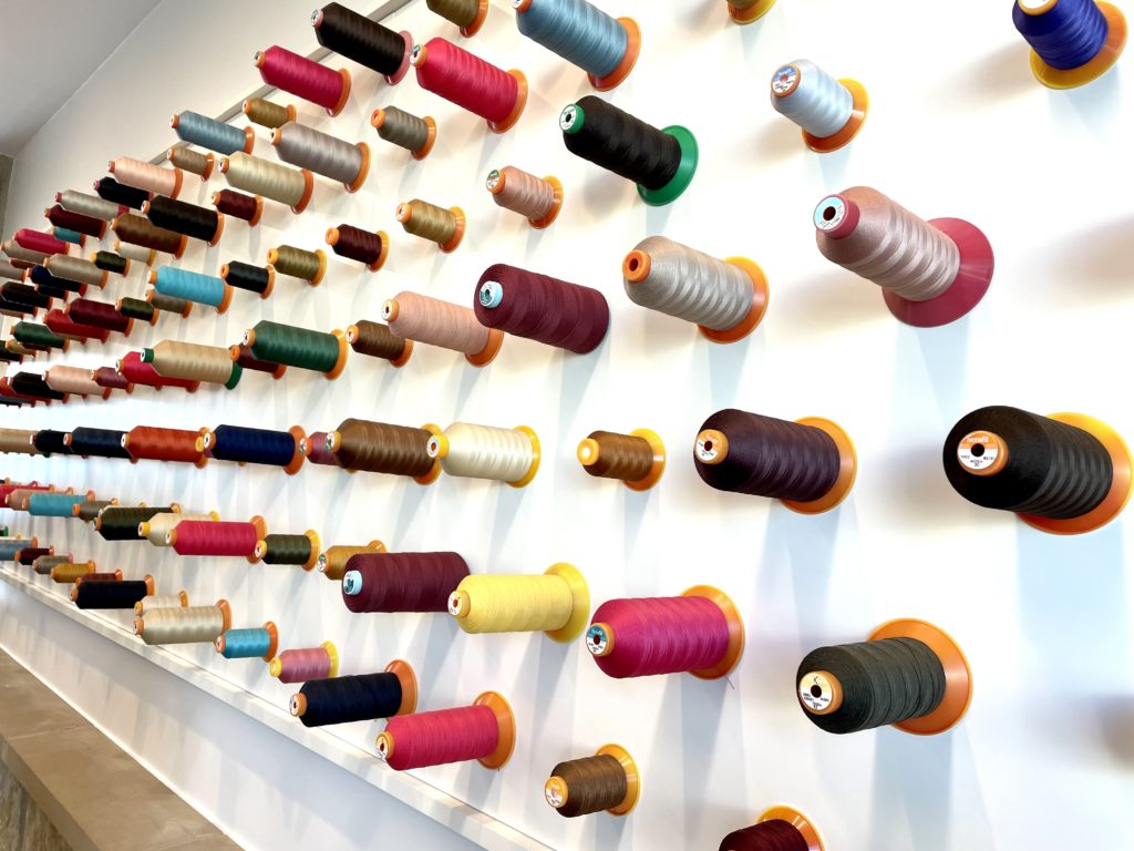 Artwork lines the walls with colorful spools of thread. Photo by Courtney Dabney.