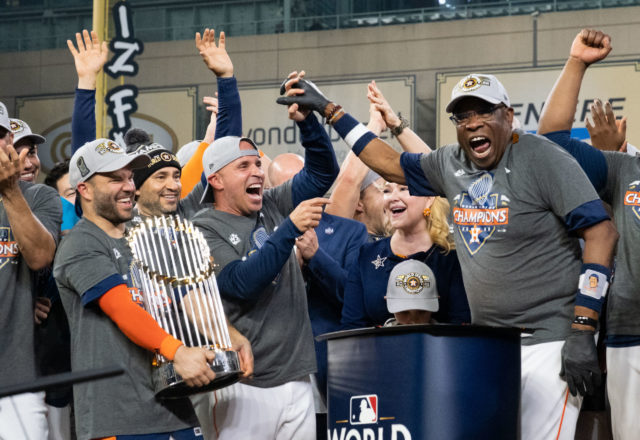 Jose Altuve could only smile at how happy manager Dusty Baker was. And continue to hug that trophy. (Photo by F. Carter Smith)