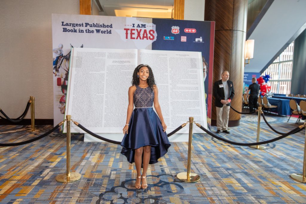 Author MADISON DEDMAN in front of the big book at the 2022 iWRITE Gala (Photo by Dave Rossman)