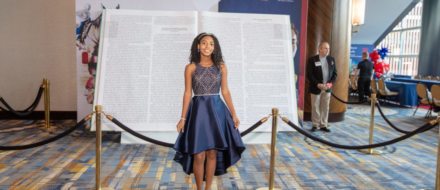 Author MADISON DEDMAN in front of the big book at the 2022 iWRITE Gala (Photo by Dave Rossman)