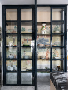 Bowen – The custom iron China cabinet is backed by salvaged antique Japanese wallpaper in the kitchen. Photo by Michael Hunter