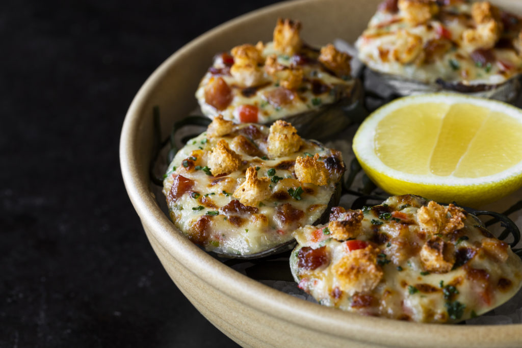 Clams casino is served at the seafood centered restaurant, Navy Blue. (Photo by Julie Soefer)
