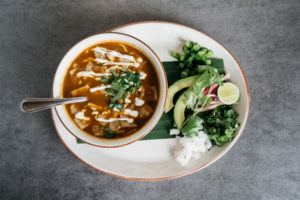 The chicken tortilla soup at Kitchen & Cantinia is made with red chiles and roasted chicken stock, hand-shredded chicken, avocado, cilantro and topped with traditional garnishes. (Photo by Caroline Fontenot)