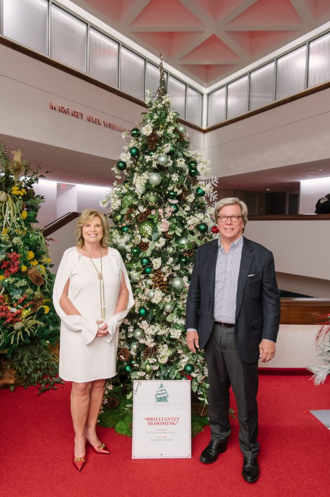 Deck the Trees co-chair Sandy Shipley and her husband George Shipley with the tree designed by Blooming Gallery. (Photo by Thomas Campbell)