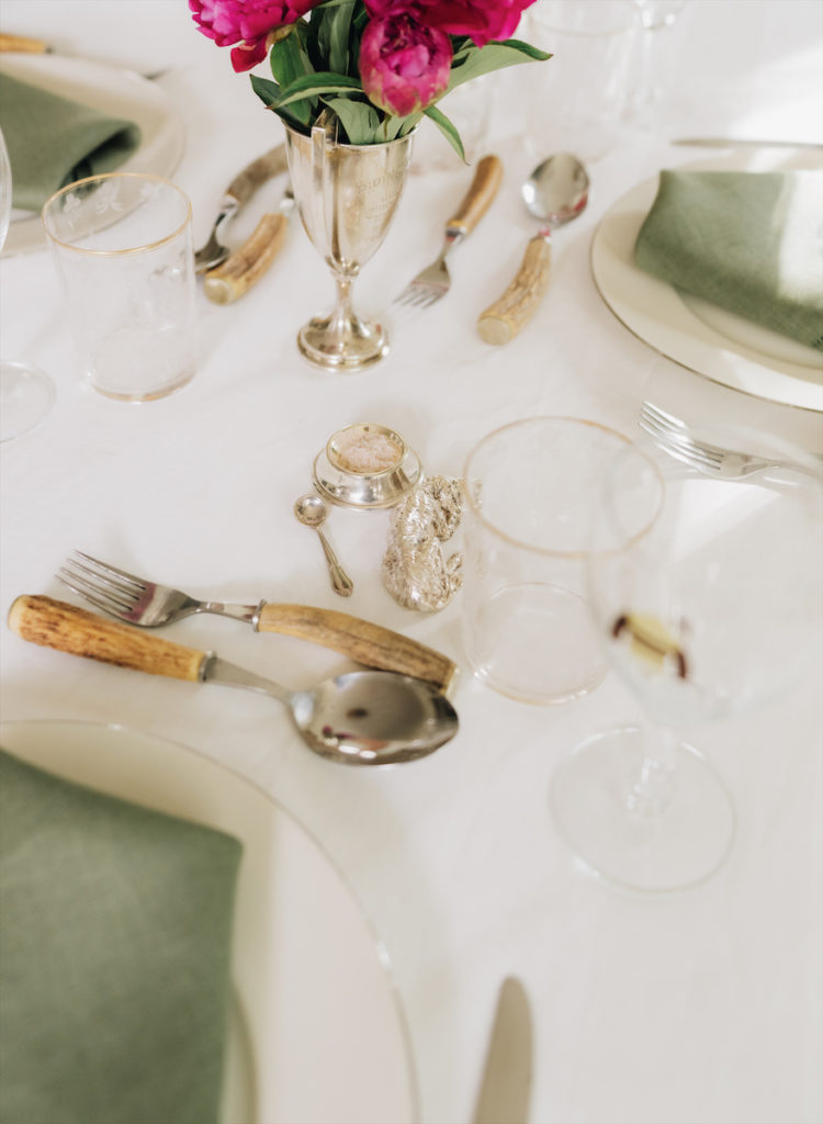 Antique horn cutlery, silver salts, crystal tumblers, and a polo trophy. (Photo by Afritina Coker)