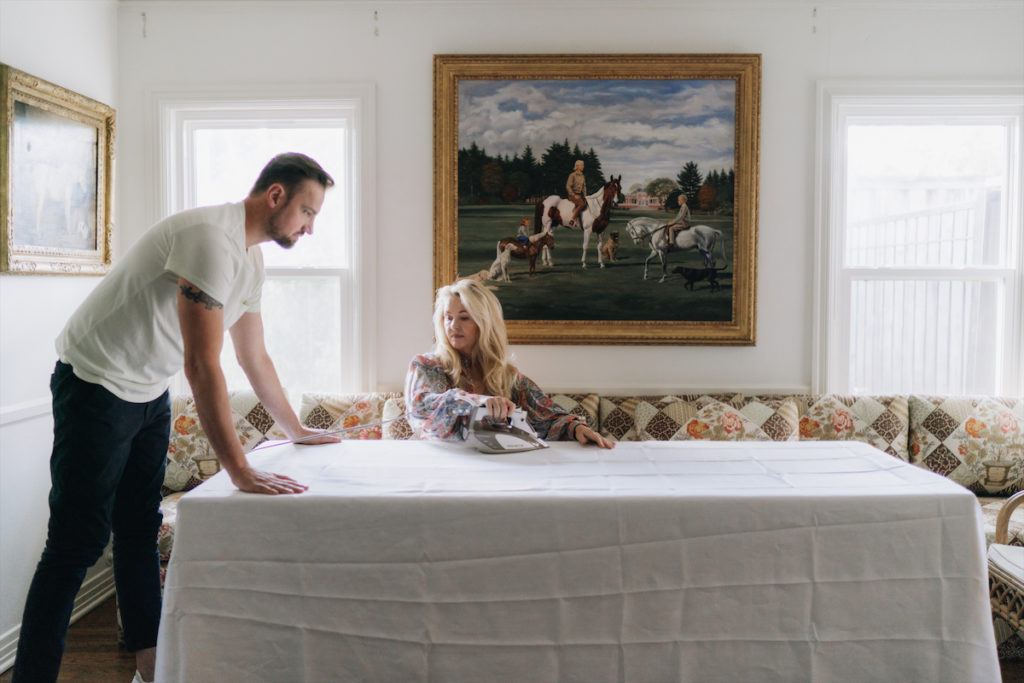 Marko Matijas and Cornelia Guest prepping the tablescape. Artist Richard Stone Reeves painted the portrait of C.Z., Cornelia, and her brother Alexander, all on horseback, in front of Templeton, the family home in Long Island. The painting was a Christmas gift from Winston to C.Z.
  (Photo by Afritina Coker)