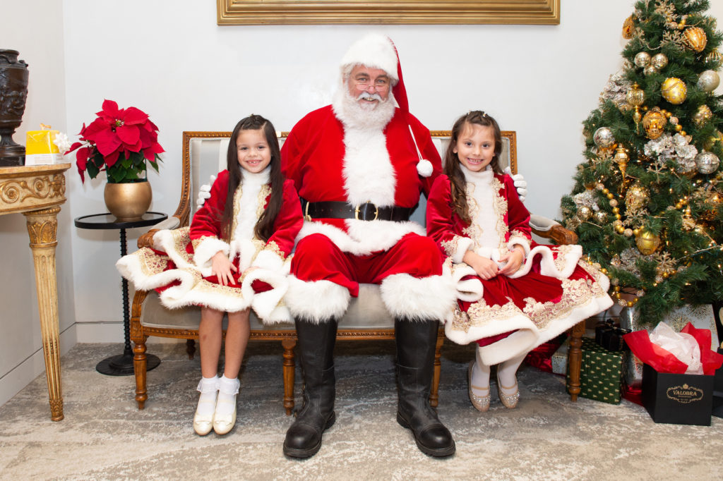 Santa gets cozy with two young ladies  at Valobra Master Jewelers Pictures With Santa & Toy Drive Party.