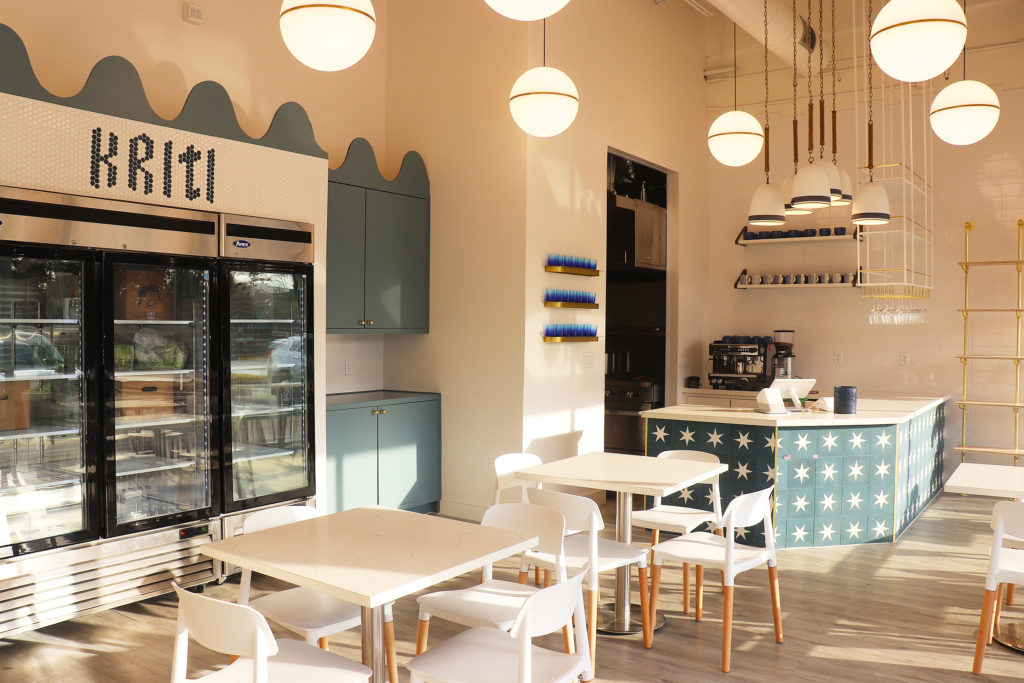 Designed by Houston-based Allie Wood Design Studio, Kriti Kitchen features modern-style dining tables and counter seating. Pops of vibrant blue cabinets and bronze globe pendant lighting give the restaurant a retro look.  (Photo by Ajna Jai)