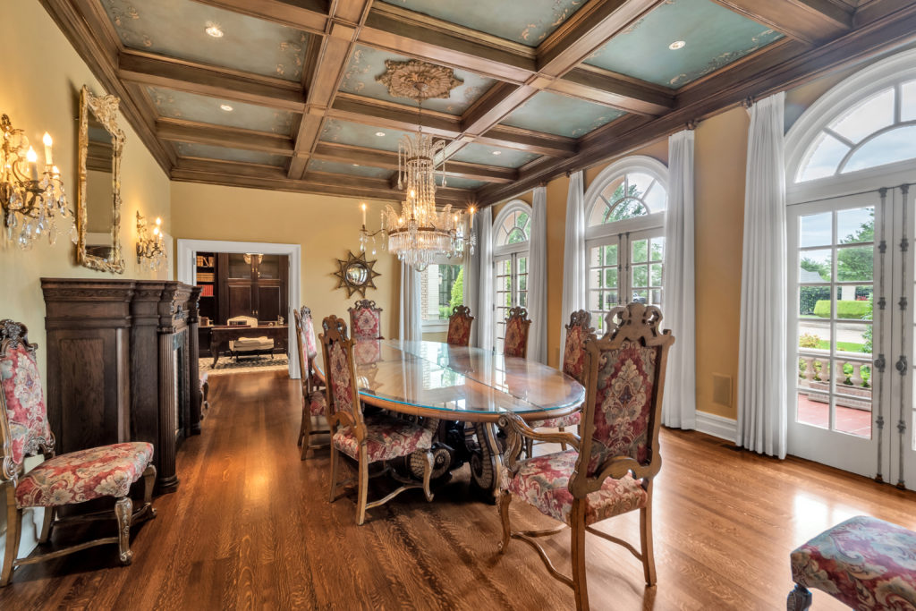 Period mantles and chandeliers as well as coffered and painted ceilings add drama in the dining room.