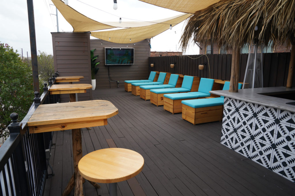 Upstairs at Tulum HTX you'll find a rooftop patio and tiki bar with cabanas and chaise lounge seating.