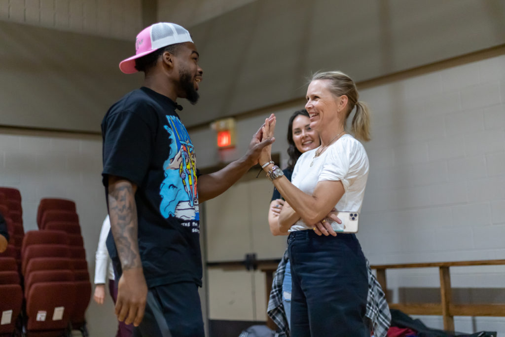 UH point guard Jamal Shead has a way of connecting with everyone. Here, he shares a five with Heather Houston, the wife of New Leaf founder David Houston. (Courtesy New Leaf real estate)