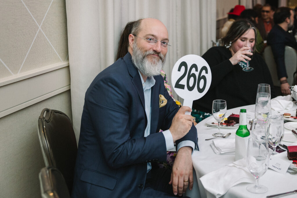 A bidder poses with a paddle at Houston Center for Photography's Print Auction & Dinner. (Photo by Johnny Than)