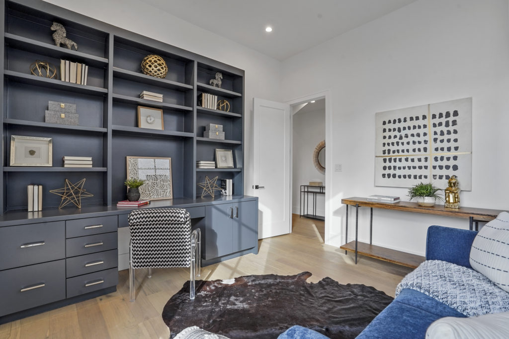 The home features floor-to-ceiling windows, an open floor plan, and a small yard.