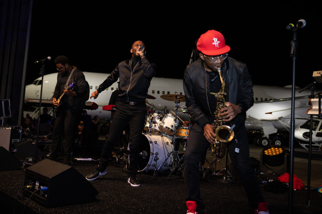 The C.I.T.Y. band on stage Billionaire Tilman Fertitta's stable of air power on display at the Houston Rockets Clutch City Foundation gala at the Landry's hangar at Hobby Airport.