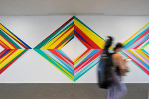 Students stroll past Odili Donald Odita's mural "Meeting Place / Painting with Changing Parts," 2022, at Alice Pratt Brown Hall, commissioned by the Moody Center for the Arts, Rice University (Photo by Sean Fleming)
