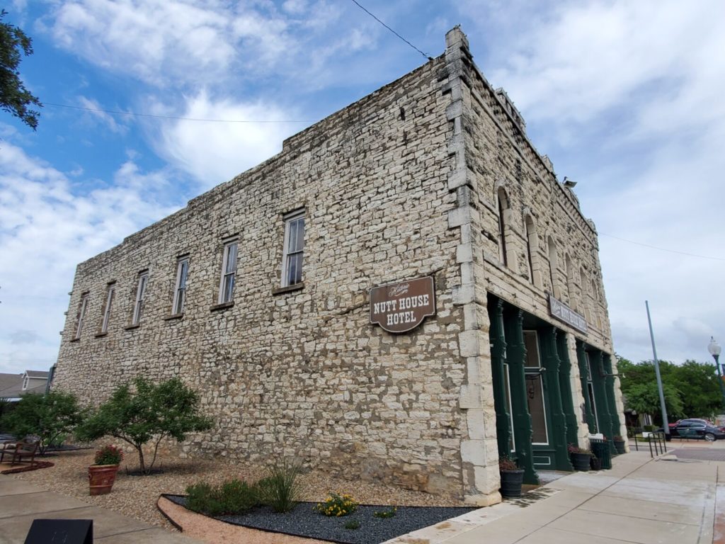 The Texas limestone façade of the Nutt House Hotel leading to the original wagon yard behind.