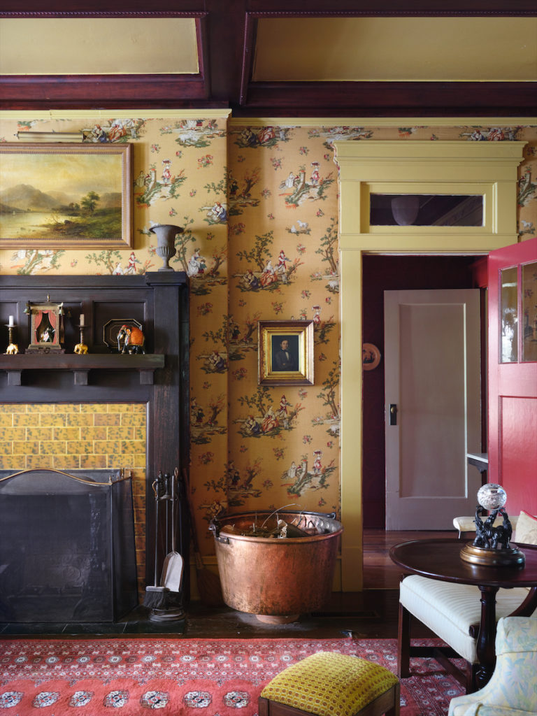 Morton’s longtime colleague Bob Cook upholstered the parlor walls in the 1980s in yellow toile fabric, similar to the original wallpaper. The fireplace’s hand-painted tile is original. (Photo by Lisa Petrole)