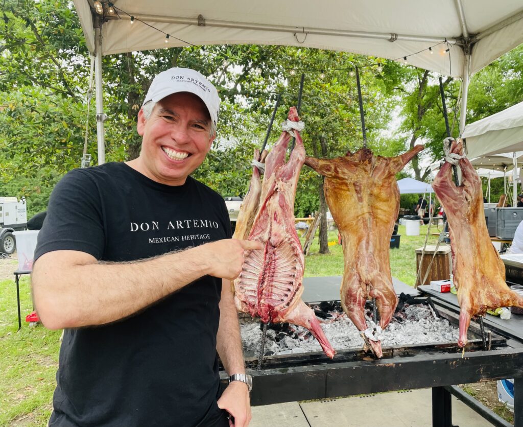 Ardrian Burciaga poses with Don Artemio's roasting cabrito at Ring of Fire. (Photo by Courtney Dabney)