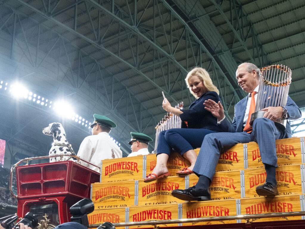 For the Astros 2023 season opener Whitney & Jim Crane enjoy the ride into Minute Maid Park along with the 2022 World Series trophy. (Photo by F. Carter Smith)