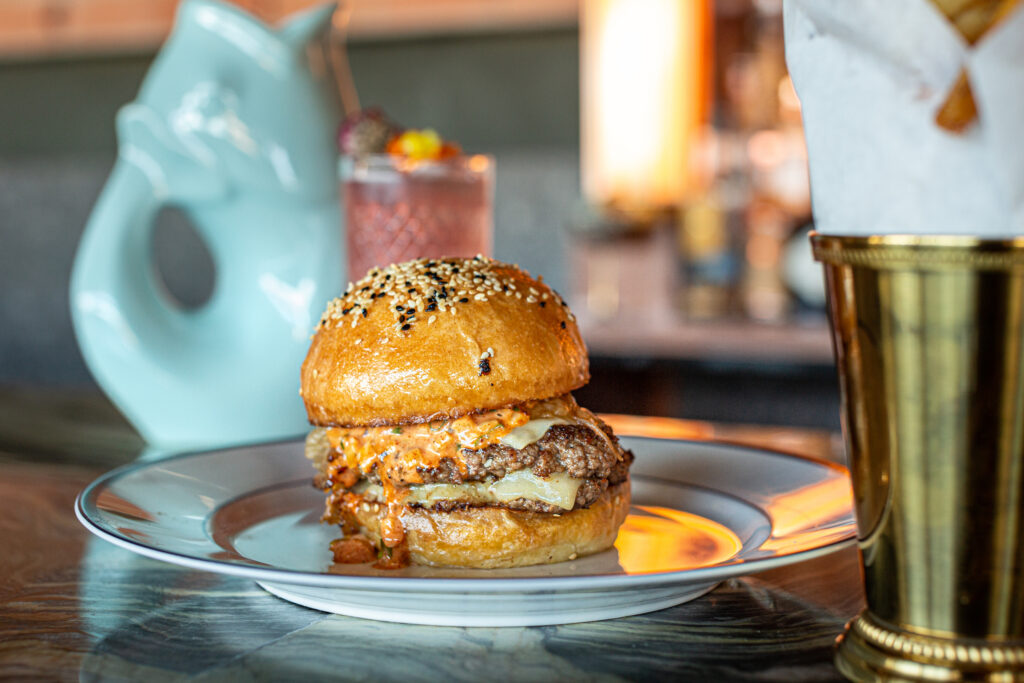 The double cheeseburger at Eau Tour has been getting lots of attention for its 60/40 combination of short rib and duck grind; apropos to its Gallic origins, it’s topped with melting gruyère, duck-fat-fried onions, and special sauce. (Photo by Jenn Duncan)
