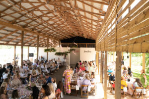 View of the Gathering Barn with guests_295_FashionintheFieldsR4S_DOrtizPhoto_041623 (Photo by Daniel Ortiz)