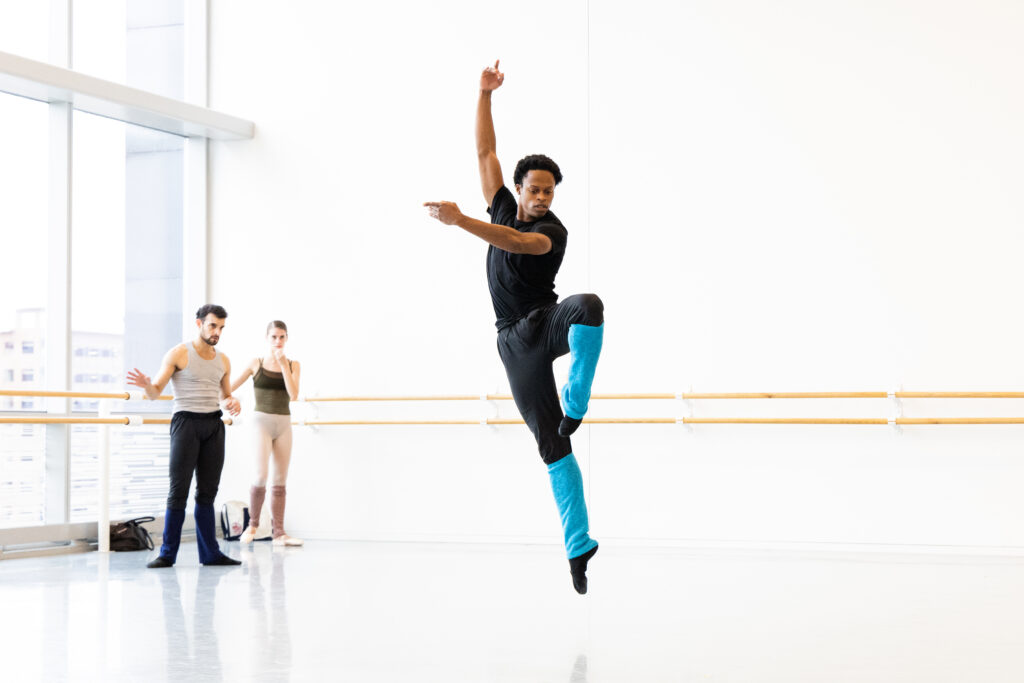 Houston Ballet Soloist Naazir Muhammad with Artists of Houston Ballet rehearsing Justin Peck’s Under the Folding Sky. (Photo by Lawrence Elizabeth Knox)