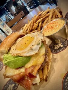 Hamburger – Jon’s Grille features the Texas Sunrise with bacon , fries, avocado, farm fresh egg and a side of Hollandaise.
