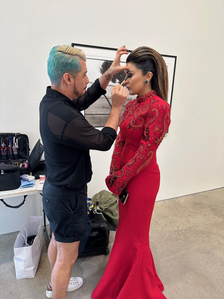 PaperCity Philanthropy in Fashion Best Dressed honoree Sneha Merchant, wearing Andrew Gn, receives a makeup touch up from artist Juan Peralta.