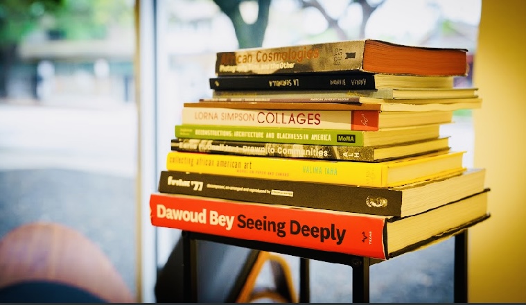 Assorted books on display at Art Is Bond. The space includes an elevated cultural library owned by gallerist Janice Bond, as well as a curated wall of books in collaboration with the Kindred Stories bookstore in Houston's Third Ward, volumes which are available for purchase. 