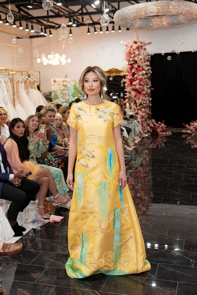 Lea Caprice in a yellow adorned gown from the collection (Photo by Celeste Cameron)