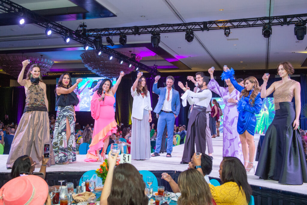 Designer Sandra Weil, Tootsies' Fady Armanious and models join in the traditional tequila toast at the Latin Women's Initiative fashion show and luncheon. (Photo by Jacob Power)