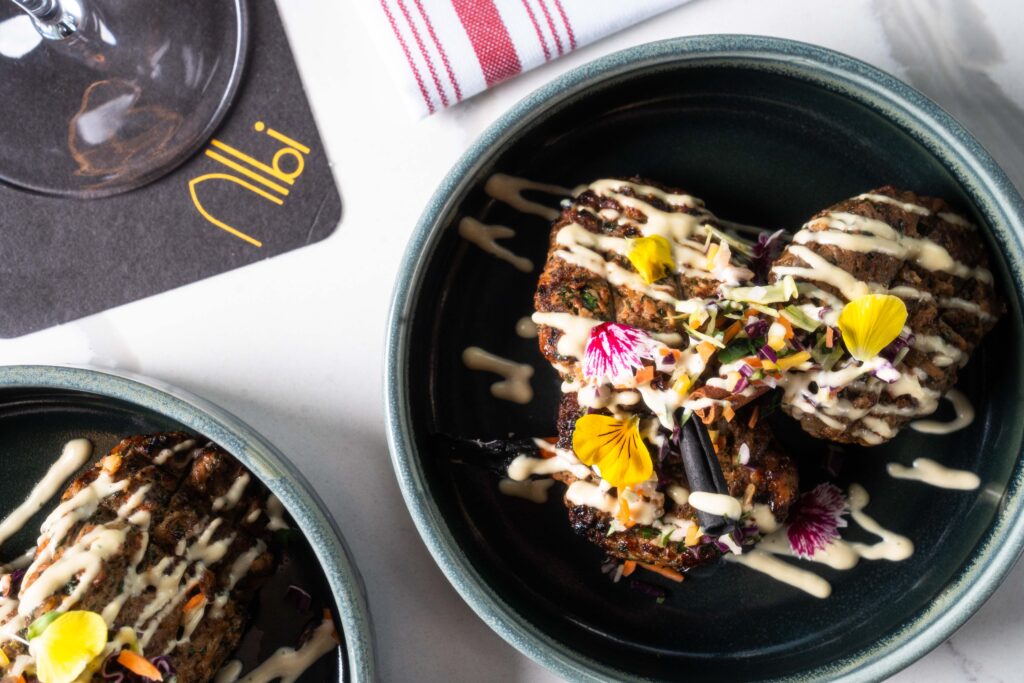 The veal kefta ($27) at Albi is akin to a meatball, is made with ground veal, topped with a dollop of tarator (tahini-based sauce), skewed on a fragrant cinnamon stick. (Photo by Michael Anthony)