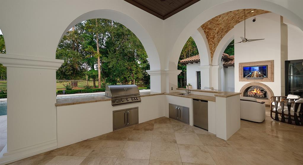 This house offers indoor-outdoor living at its finest, with an outdoor kitchen and seating area beside the pool. 