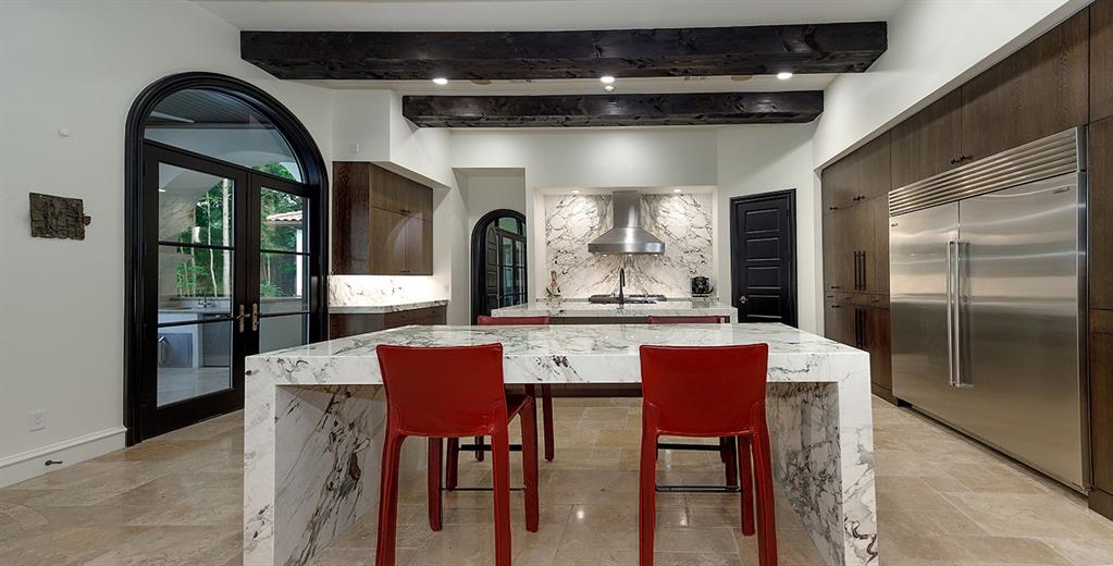 Wooden beams and warm-white marble counters perfectly complement the kitchen aesthetic. 