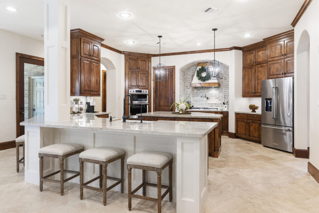 The kitchen at 7421 Enchanted Stream Drive boasts quartzite countertops, new stainless-steel appliances, a gas cooktop and double ovens, German Smear brick, pot filler, custom hood vent and an abundance of storage.