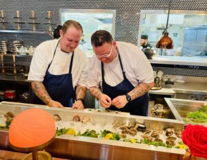 Le Margot – Graham Elliot working on the oyster course at Saturday’s launch party. (Photo by Courtney Dabney)