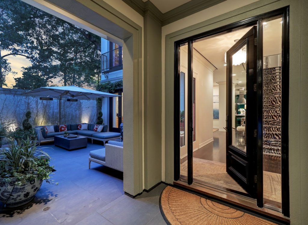 Glass doors open to the interior courtyard The turquoise kitchen in the luxurious 'Tuscan Villa' townhome at 5722 Logan Lane (Photo by TK Images/Compass)