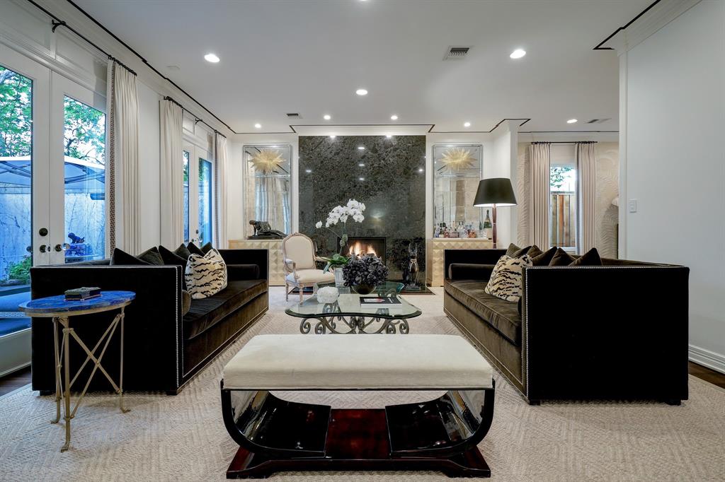The formal living room with gas fireplace in the luxurious 'Tuscan Villa' townhome at 5722 Logan Lane (Photo by TK Images/Compass)