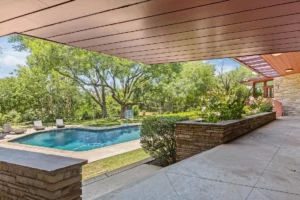 Brachman – Patio stonework and heavy wooden overhangs lead to the grounds and pool