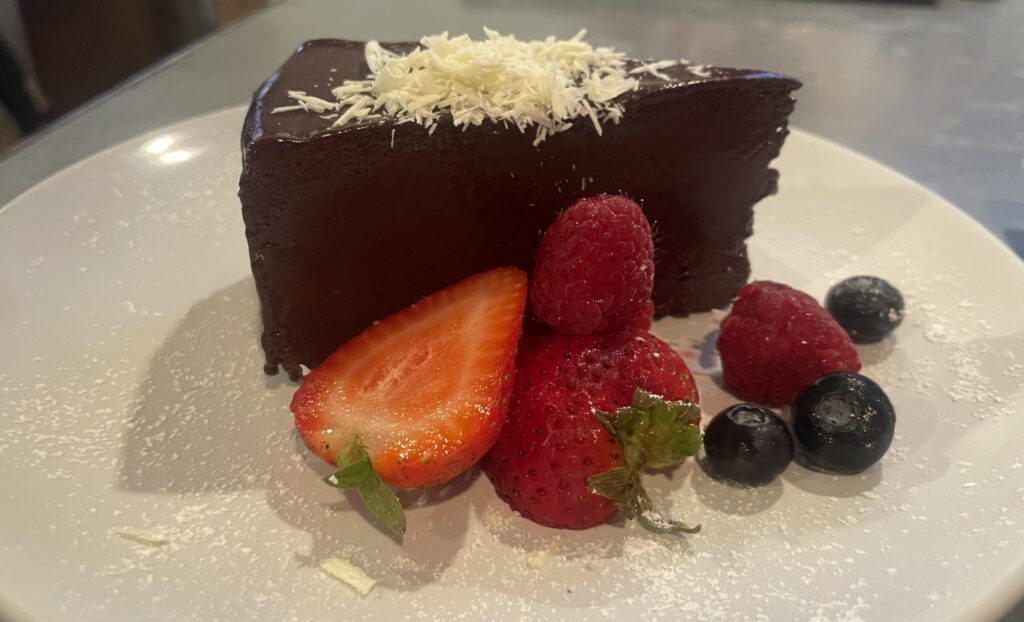 The flourless chocolate cake at The Butler House is dense, but well balanced by the fruit and white chocolate shavings.