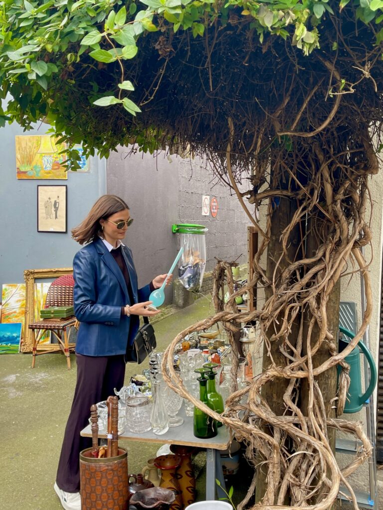 Lily Barfield, founder of Lily Vintage Finds, shopping for antiques at Marché aux Puces de Saint-Ouen in France.